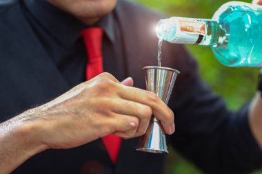 Meyve kokteyli hazırlamak için barmenin elindeki jigger bira içti ve meyve kokteyli bıraktı. Partide eğlenmek ve eğlenmek için.