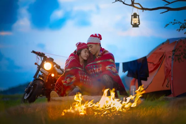 couple lover motorbike in moment sweet at countryside with campfire in cold place of meadow lake side