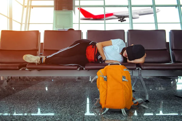 woman lost flight at coming late to checking in boarding pass to the airline gate, sleep on the chair waiting for next flight booking progress