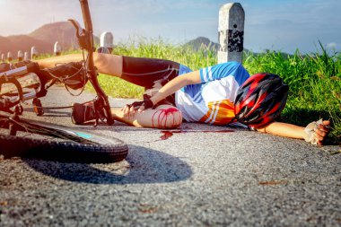 woman cycling in hurt and injuried of leg after accident clashed, with mortal wound and bleeding of blood flow on the surface of street roa