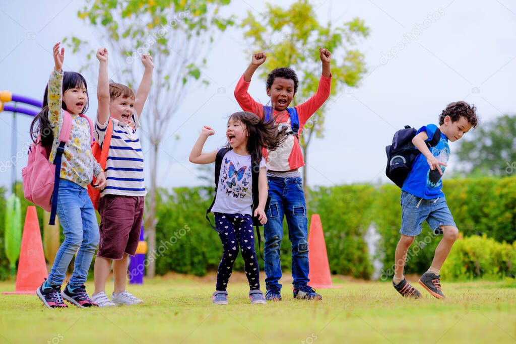 kids preschool kindergarten enjoy and happy jumping on the field of playground after school class is over to retuning home