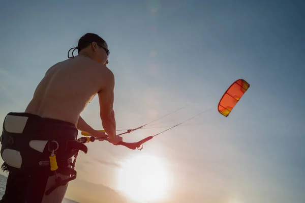 スポーツマンは夏休みの日没時に海のカイトサーフィンで遊ぶことを楽しむ 海のスポーツ — ストック写真