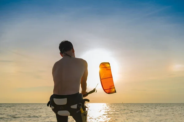 Sport man enjoy playing in the sea kite surf at sunset in summertime vacation, sea sport, aim to destination of life