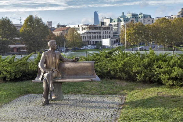 A bronze statue, depicting a smiling Reagan sitting on a bench with crossed legs, can be found in Rike Park. — Stock Photo, Image