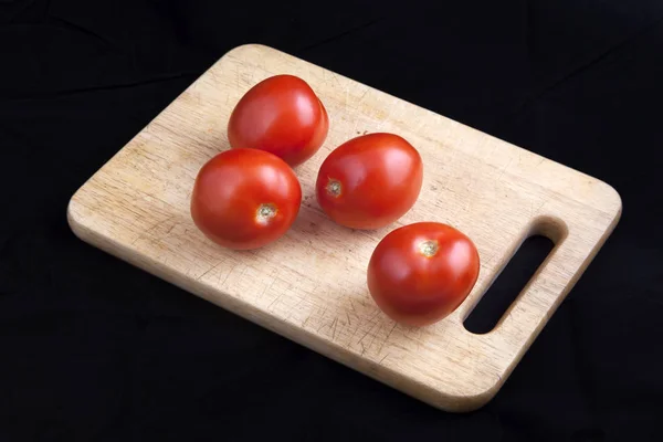Tomates en una tabla de cortar — Foto de Stock