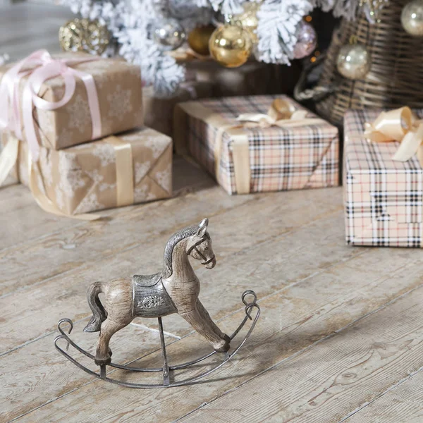 Small wooden rocking horse under the Christmas tree with gifts — Stock Photo, Image