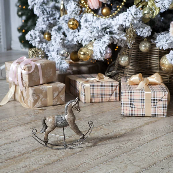 Piccolo cavallo a dondolo in legno sotto l'albero di Natale con regali — Foto Stock