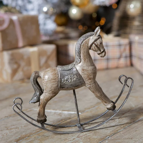 Small wooden rocking horse under the Christmas tree with gifts — Stock Photo, Image