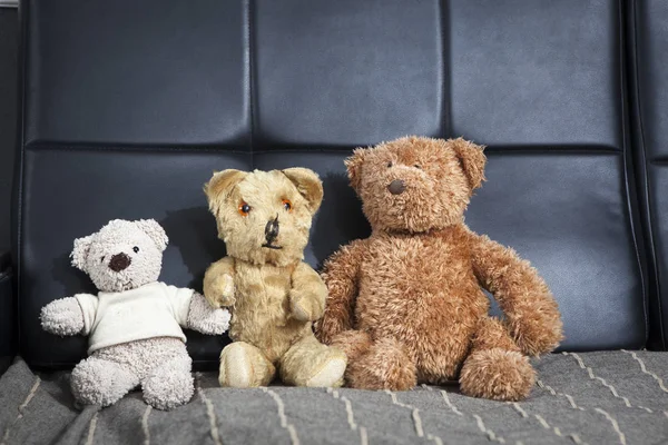 Family of three old vintage teddy-bear sitting on sofa — Stock Photo, Image
