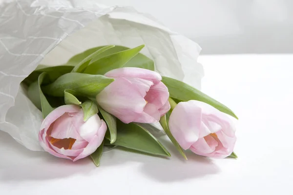 O buquê de flores de tulipa rosa de aniversário envolto em papel branco — Fotografia de Stock