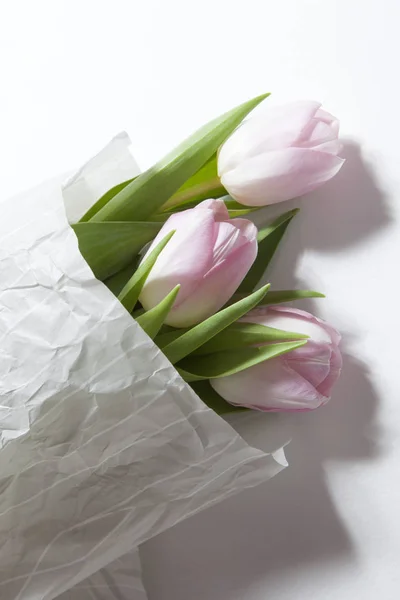 O buquê de flores de tulipa rosa de aniversário envolto em papel branco — Fotografia de Stock