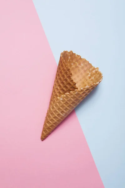 空的蛋卷冰淇淋上蓝色和粉红色的背景 — 图库照片