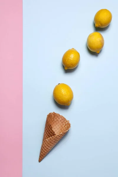 Cono vacío de helado con limón sobre un fondo rosa y azul — Foto de Stock
