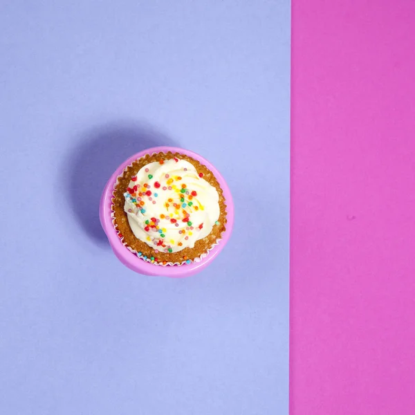 Cupcakes con crema blanca sobre fondo rosa y azul , — Foto de Stock