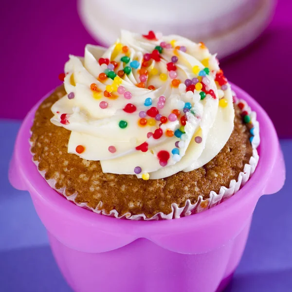 गुलाबी और नीले पृष्ठभूमि पर सफेद क्रीम के साथ कपकेक , — स्टॉक फ़ोटो, इमेज