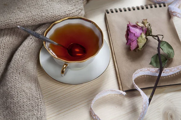 Den Vintage koppen te insvept i en ull pläd och pad med en torr ros på bordet — Stockfoto