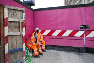 Çalışma sırasında bir ara. Turuncu cüppeli bir pembe arka plan duvar üzerinde dinlenme işçi
