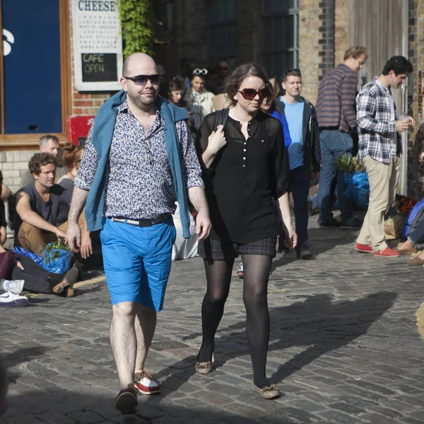 The man in blue shorts and woman in black are on Columbia Road — Stock Photo, Image