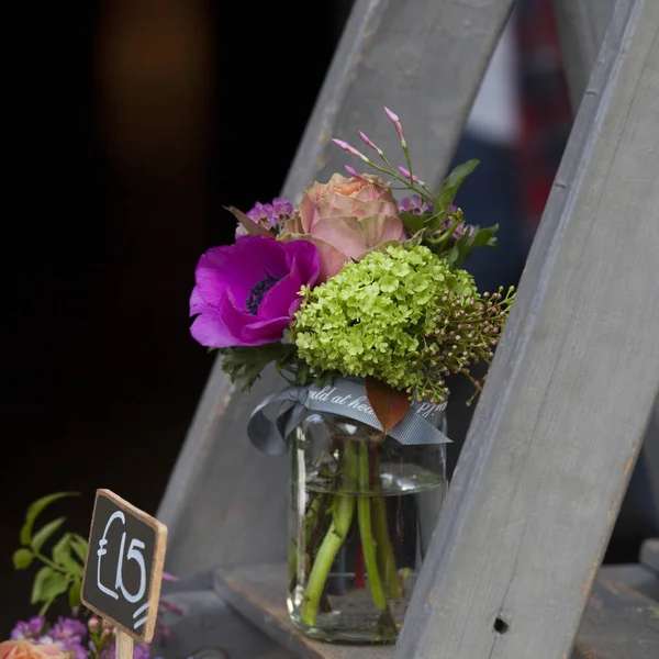 Kleine Sträuße für besondere Anlässe aus Tulpen, Anemonen und Hortensien in einer Dose auf der Treppe zum Verkauf — Stockfoto