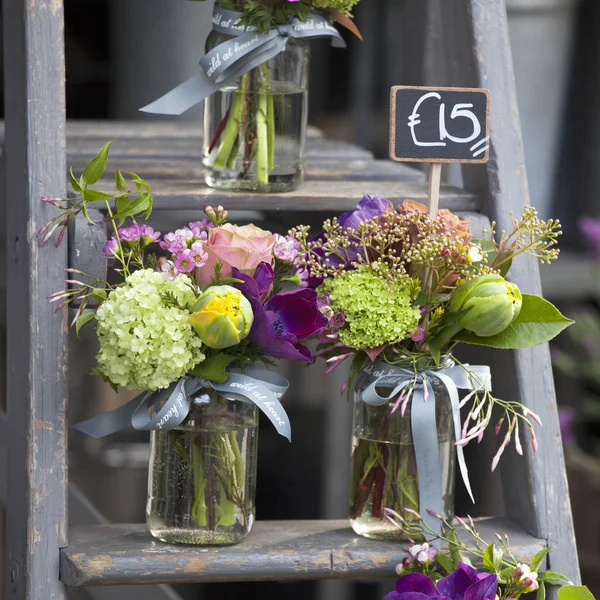 Small bouquets for special occasions from tulip, anemone and hydrangeas in a can on the stairs for sale