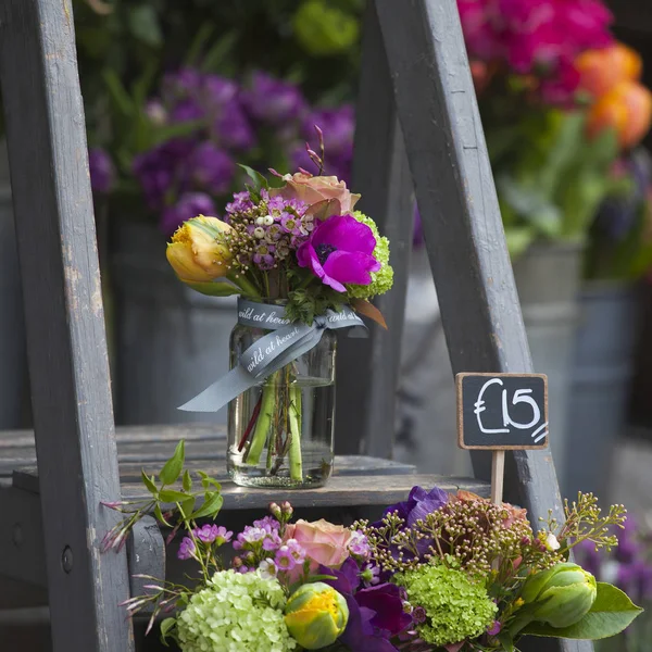 Kleine boeketten voor speciale gelegenheden van tulip, anemone en hortensia's in een blikje op de trappen te koop — Stockfoto