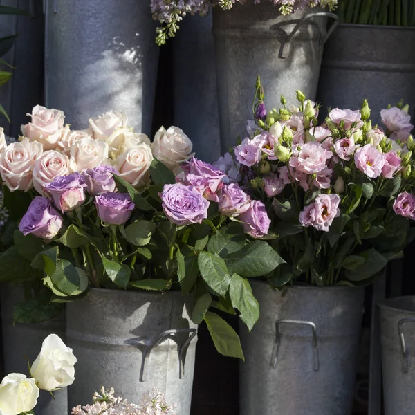 The Bouquets of lisianthus, freesias and lilacs in large aluminum buckets — Stock Photo, Image