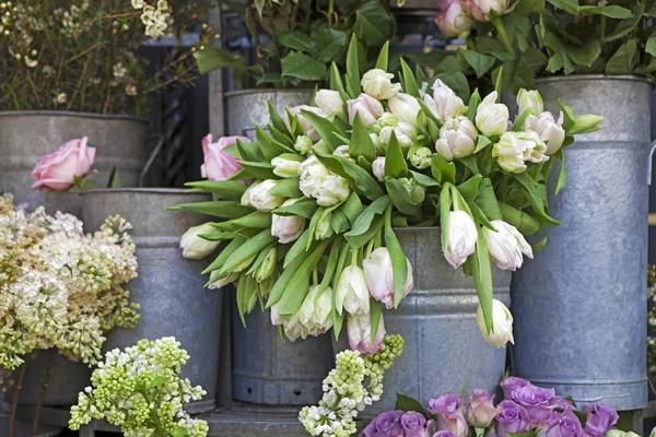 Le seau avec un bouquet de tulipes blanches et un vase avec des roses rouges comme décoration pour l'entrée de la maison — Photo