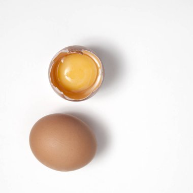 Bütün yumurta beyaz bir arka plan üzerinde kırık yumurta yanındaki