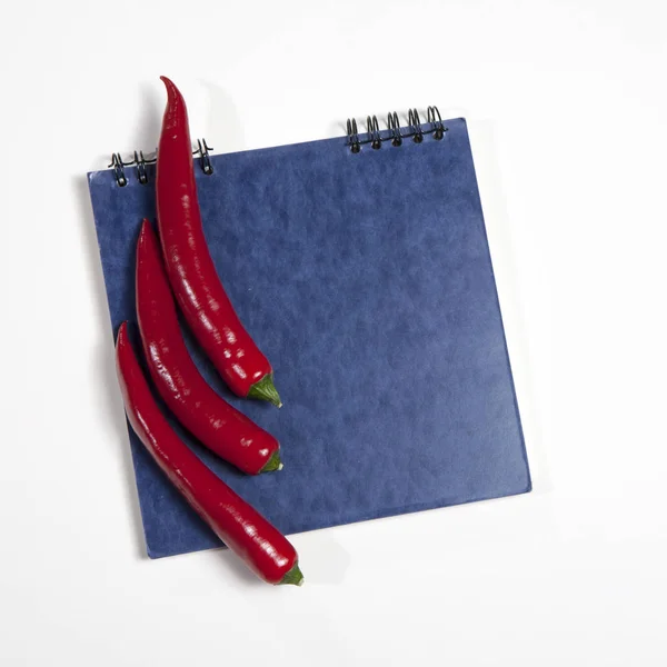 De postkaarten voor recepten. Ansichtkaarten voor recepten. Blauwe schetsblok en rode peper als een frame op een witte achtergrond. — Stockfoto