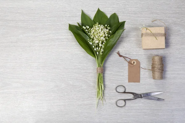 Букет цветов и листьев с коробкой подарков на деревянном фоне. Копирование пространства — стоковое фото