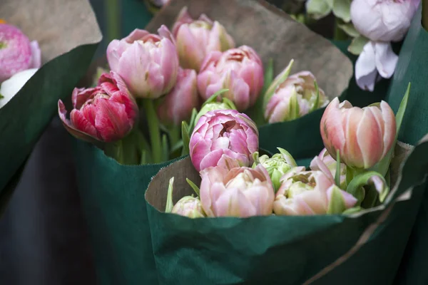 Bukiet róż tulipany w papier pakowy zielony — Zdjęcie stockowe