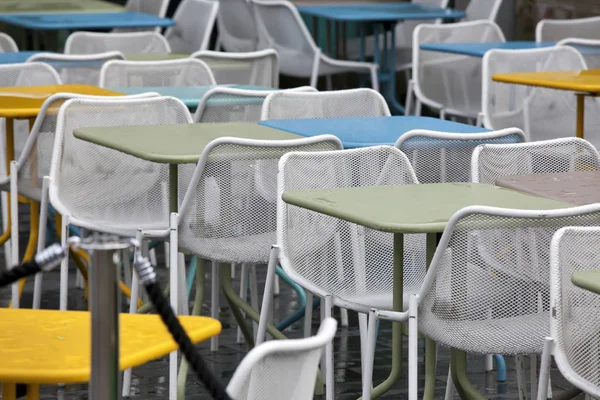 A zona do restaurante com cadeiras plásticas coloridas e azul, amarelo, mesas brancas no átrio do shopping. Belo interior — Fotografia de Stock