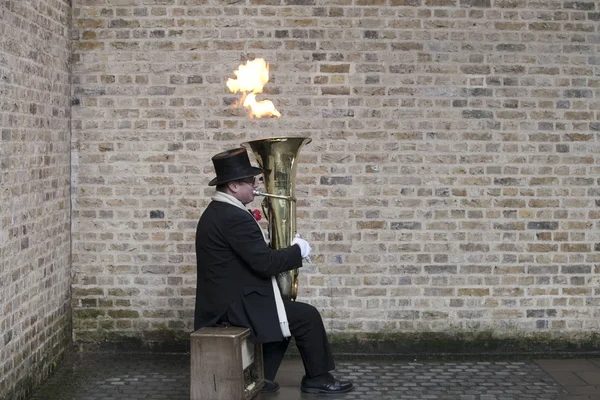 Male actor is playing on a trumpet blowing a fire — Stock Photo, Image