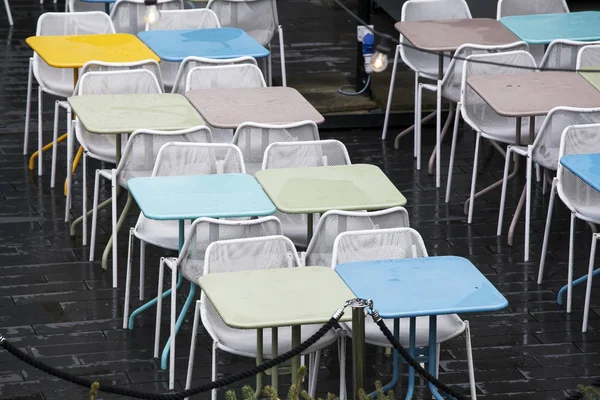 A zona do restaurante com cadeiras plásticas coloridas e azul, amarelo, mesas brancas no átrio do shopping. Belo interior — Fotografia de Stock