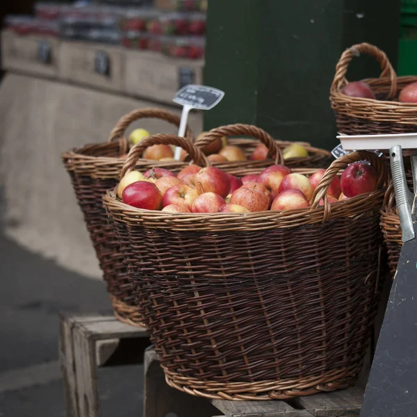 Le panier en osier de pommes rouges avec une étiquette de prix sur le marché à vendre — Photo
