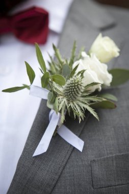 Beyaz tonlarda lisianthus, gül, Yıldızçiçekleri ve okaliptüs düğün yaka çiçeği