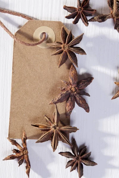 Sementes de anis em forma de estrela em um fundo de madeira branco — Fotografia de Stock