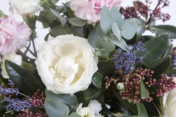 Der Hochzeitsstrauß einer Braut aus einer Rose, einer rosa Nelke, Eukalyptus auf einem Holztisch — Stockfoto