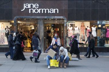 Bir adam onun karısı paketi satın Jane Norman yakınındaki yardımcı olur.