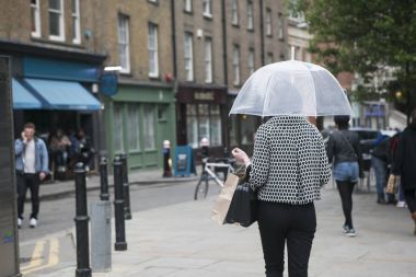Siyah ve beyaz ekose moda ceket Londra zemin karşı şeffaf bir şemsiye altında bir kız