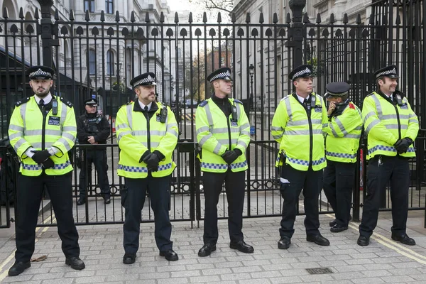 Palace of Westminster yakınındaki terör saldırısının kurbanları anısına düzenlenen bahar çiçekleri yanında kapıdaki polis memurları standı