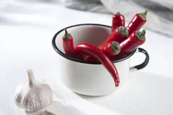 The Spicy red pepper in a white enamel cup. Autumn recipes. Copy space — Stock Photo, Image