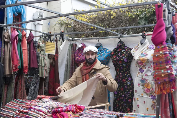 Le vendeur de foulards sur Portobello Road sur fond de foulards indiens multicolores — Photo