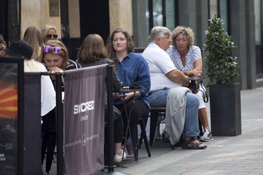 İnsanlar Piccadilly Circus yakınındaki sokak bir kafede oturuyor