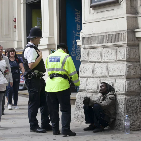 Polícia falando com um afro-americano com capuz cinza — Fotografia de Stock