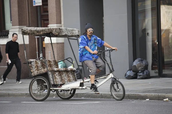 人力车在蓝色衬衫和太阳镜骑着它去城市寻找客户 — 图库照片