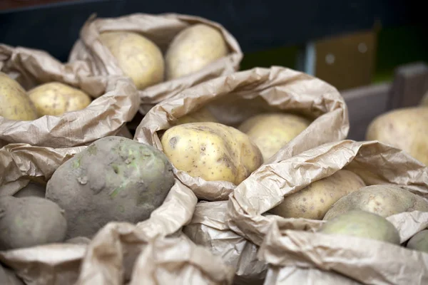 Las patatas Frescas de la nueva cosecha en las bolsas de papel están en el mercado —  Fotos de Stock