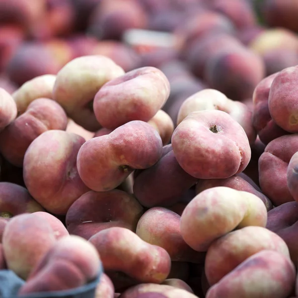 A variedade de pêssegos no mercado para venda. Os pêssegos são um armazém de vitaminas — Fotografia de Stock