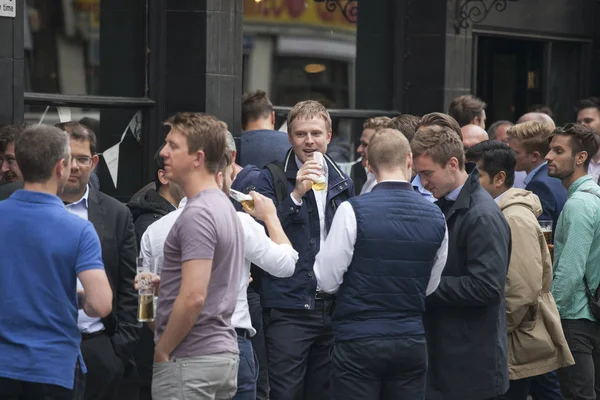 Eine bunte Menschenmenge sitzt vor der Kneipe, trinkt Bier, unterhält sich mit Freunden. Stadtmarkt — Stockfoto