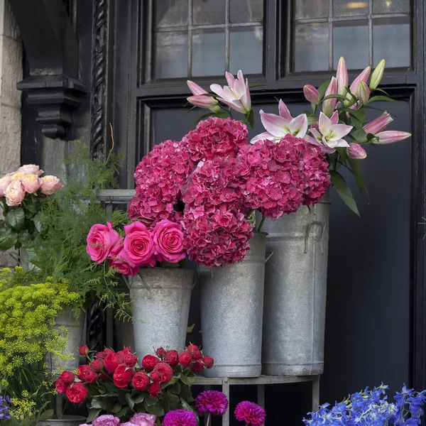Pembe, mor güller ve ortanca gibi soluk beyaz lilyum çiçek Dükkanı girişinde Satılık — Stok fotoğraf
